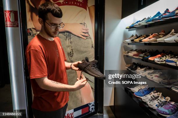 Seller shows off the new Adidas Yeezy Boost 350 shoe model at the reseller store. The German manufacturer of sports shoes Adidas has launched the...