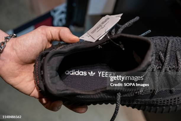 Seller shows off the new Adidas Yeezy Boost 350 shoe model at the reseller store. The German manufacturer of sports shoes Adidas has launched the...