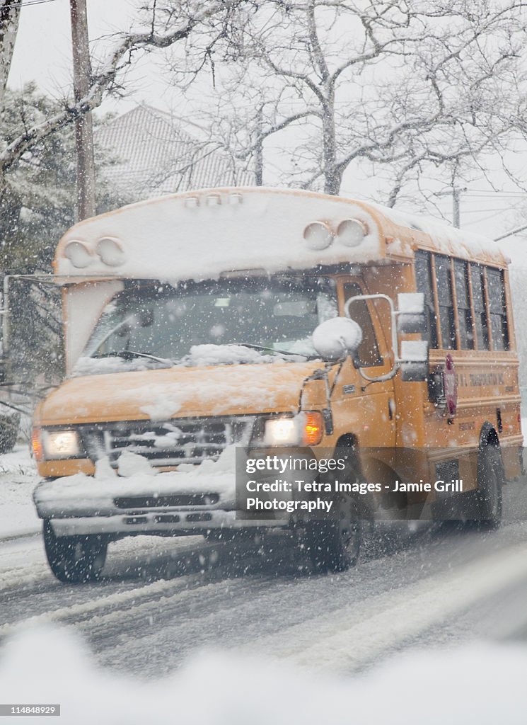 USA, New Jersey, Jersey City, school bus on road during blizzard