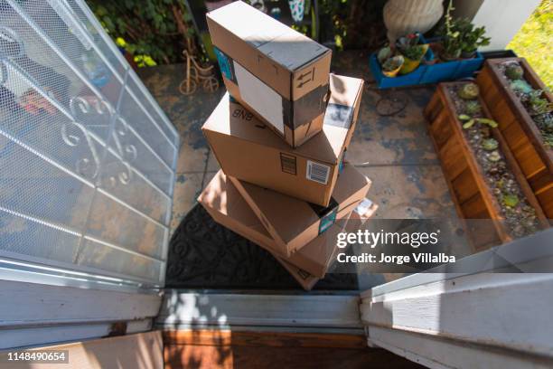 cardboard package delivery at front door - amazon boxes stock pictures, royalty-free photos & images