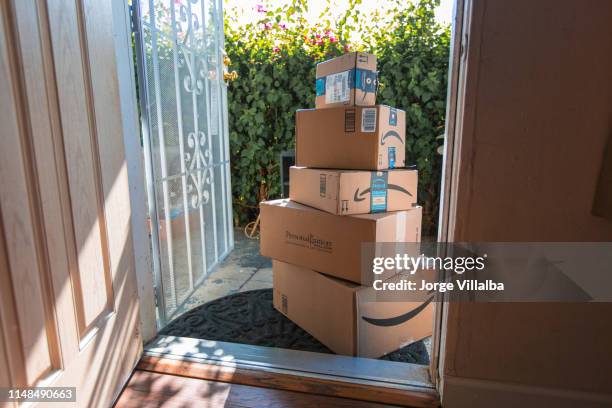 cardboard package delivery at front door - amazon boxes stock pictures, royalty-free photos & images