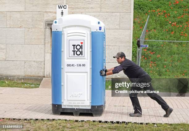 June 2019, Bavaria, Nuremberg: A worker pushes a Dixiklo onto the grounds of Rock im Park. The music festival lasts until 9 June 2019. Photo: Rachel...