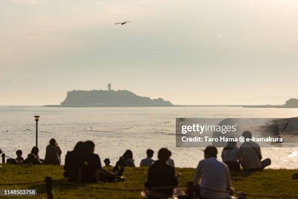 people on the sunset beach in japan - enoshima island stock pictures, royalty-free photos & images