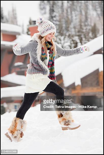 usa, utah, salt lake city, young woman walking through snow in resort - bontmuts stockfoto's en -beelden