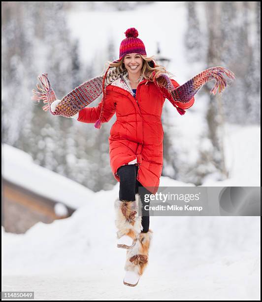 usa, utah, salt lake city, portrait of young woman skipping in snow - winter coat stock pictures, royalty-free photos & images