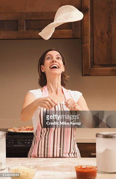 usa, utah, lehi, woman tossing dough in kitchen - pizza toss foto e immagini stock