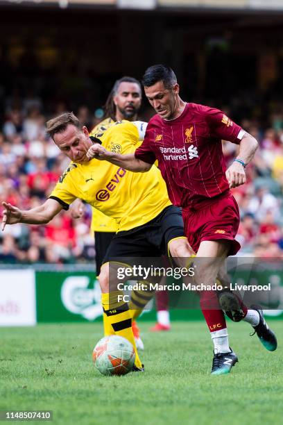 Luis Garcia of Liverpool FC attempts a kick while being defended by Jorg Heinrich of Borussia Dortmund during the match between Liverpool FC Legend...