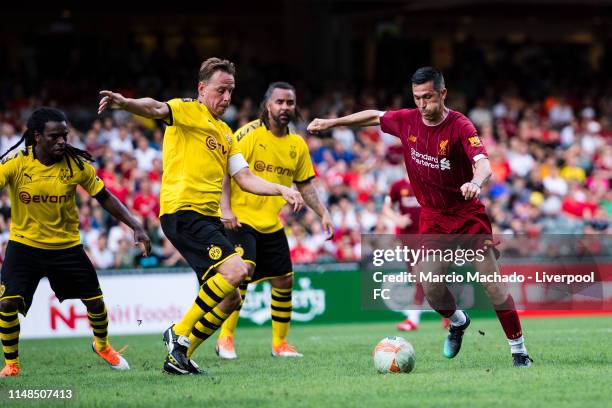 Luis Garcia of Liverpool FC attempts a kick while being defended by Jorg Heinrich of Borussia Dortmund during the match between Liverpool FC Legend...
