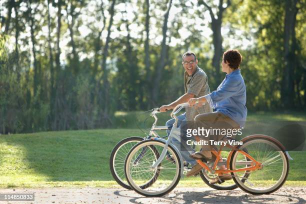 hispanic couple riding bicycles - 50 59 years stock pictures, royalty-free photos & images