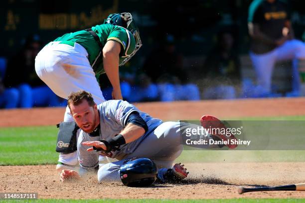 Jordan Luplow of the Cleveland Indians slides into home before the tag by Ramon Laureano of the Oakland Athletics during the ninth inning at...