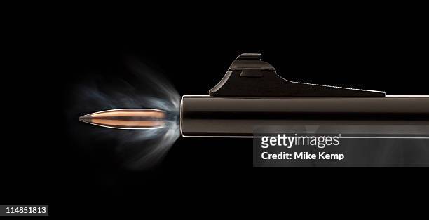 studio shot of bullet coming out of gun barrel - fastest gun ストックフォトと画像