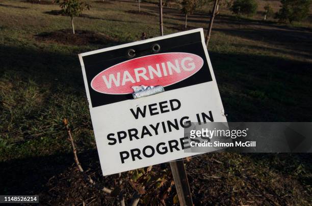 'warning: weed spraying in progress' sign in a paddock - spraying weeds stock pictures, royalty-free photos & images