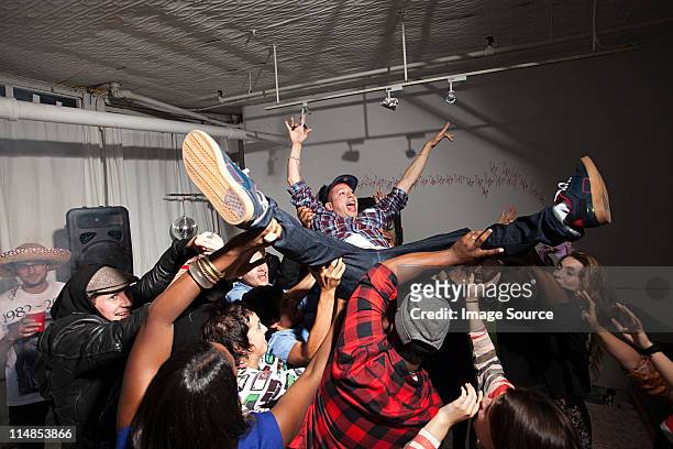 man crowd surfing at party - crowdsurfing stock pictures, royalty-free photos & images