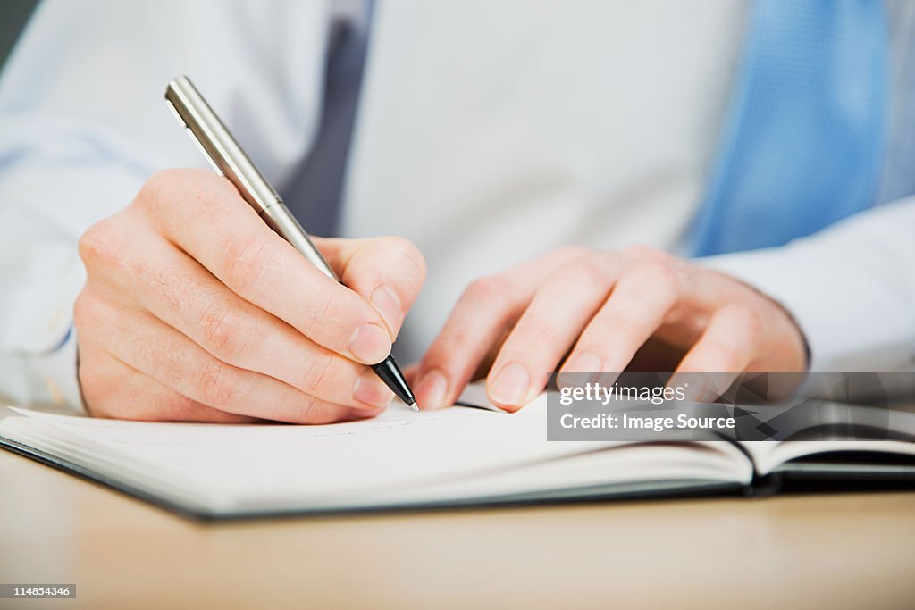 Office worker writing in diary
