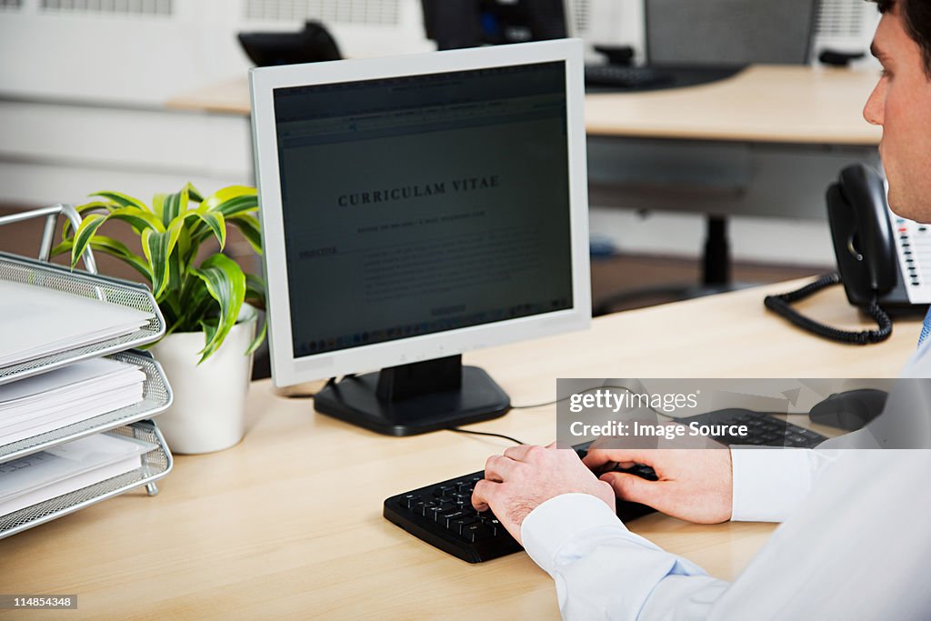 Office worker using computer to update resume