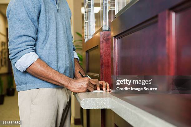 kunde einen scheck bei der bank counter - scheck stock-fotos und bilder