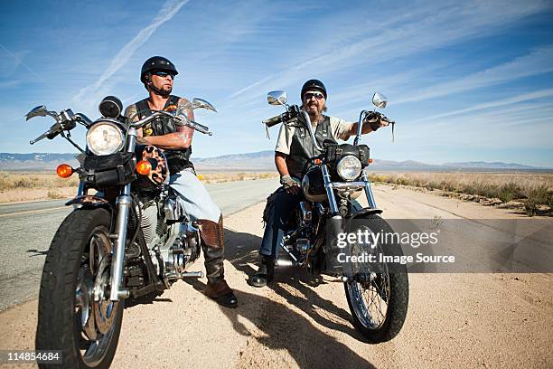 two men parked on motorcycles at roadside - motorcycle man stock pictures, royalty-free photos & images