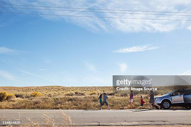family with car on desert road - california road trip stock pictures, royalty-free photos & images