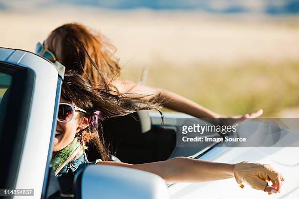 zwei junge frauen in cabrio auto - fahrspaß stock-fotos und bilder