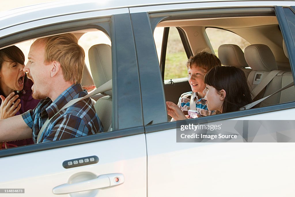 Family driving in car, parents shouting at children