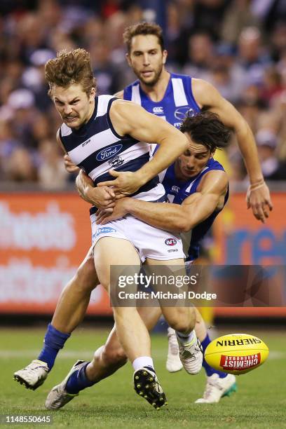 Robbie Tarrant of the Kangaroos tackles Tom Atkins of the Cats during the round eight AFL match between the North Melbourne Kangaroos and the Geelong...