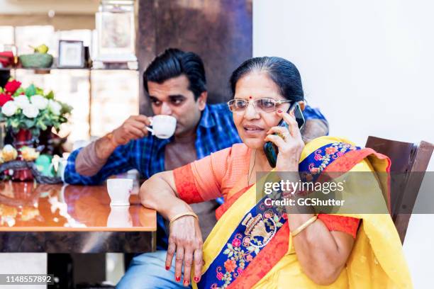 senior woman talking on the mobile phone - old houses in mumbai stock pictures, royalty-free photos & images