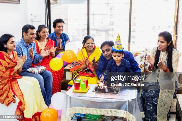 family celebrating kid's birthday - indian family party stock pictures, royalty-free photos & images
