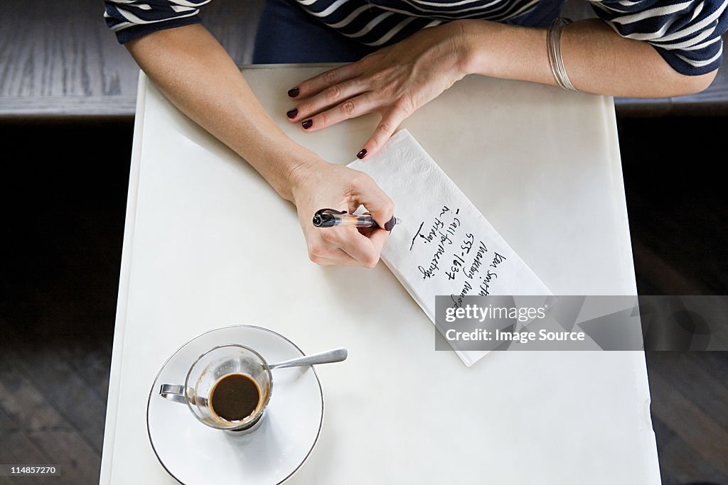 Woman writing note on napkin