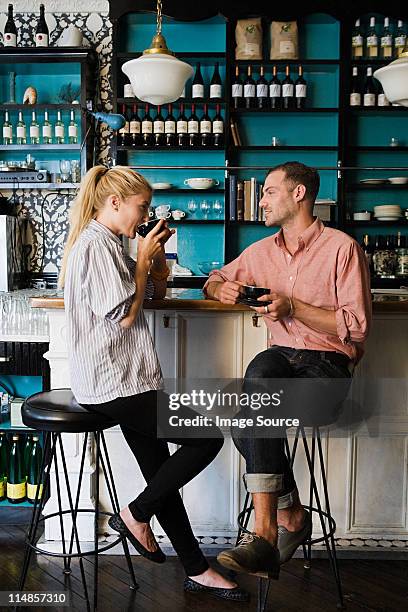 couple at coffee bar - sitting drinking coffee man stock-fotos und bilder