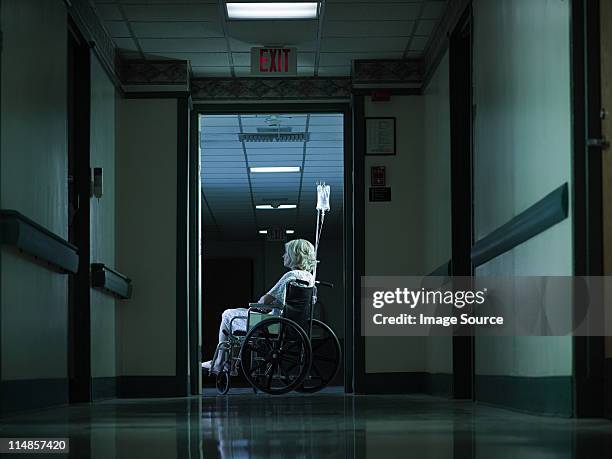 female patient in wheelchair with intravenous drip - examination gown stock pictures, royalty-free photos & images