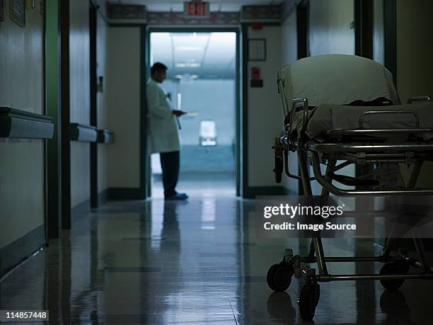 männlichen arzt im krankenhaus-korridor - stretcher stock-fotos und bilder