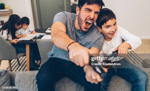 vader en zoon spelen video game - game six stockfoto's en -beelden