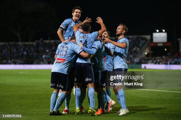 Alex Brosque of Sydney FC celebrates with team mates after scoring a goal as Joshua Brillante jumps over the top during the A-League Semi Final match...