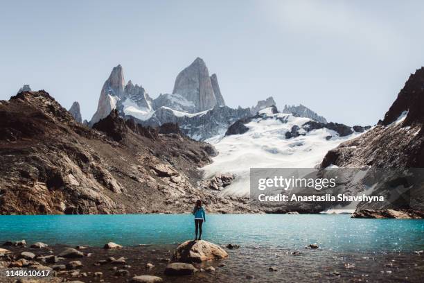 mujer mirando la montaña fitz roy y la laguna turquesa en el chaltén, argentina - patagonia fotografías e imágenes de stock