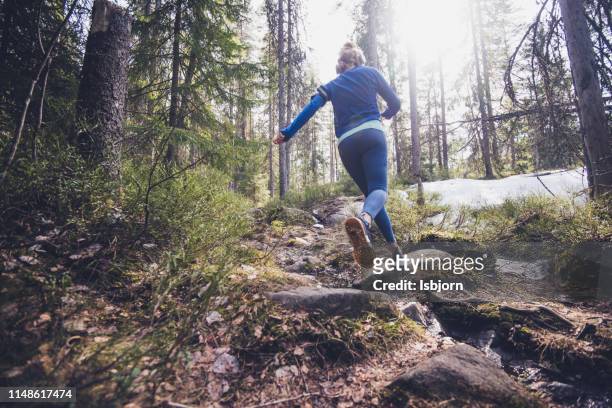 woman trail runner draait in het bos. - train tracks stockfoto's en -beelden