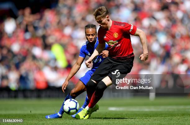 Scott McTominay of Manchester United battles for possession with Bobby Reid of Cardiff City during the Premier League match between Manchester United...