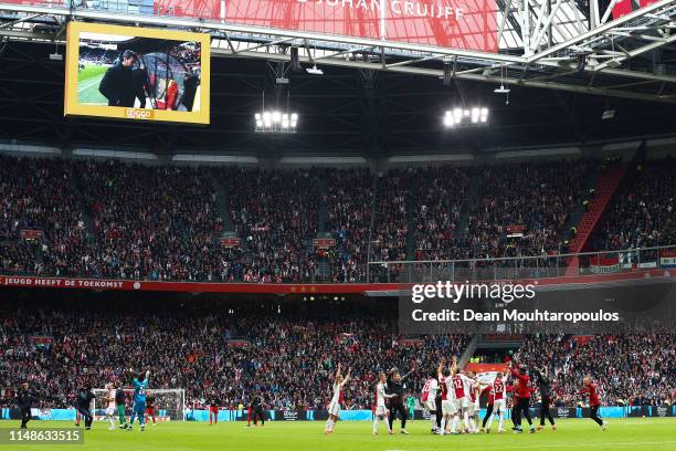 Ajax players celebrate on the pitch winning Eredivisie title as they watch on a big screen PSV losing its match against AZ Alkmaar at the end of the...