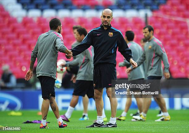 Josep Guardiola manager of FC Barcelona shakes hands with player Daniel Alves during a Barcelona training session prior to the UEFA Champions League...