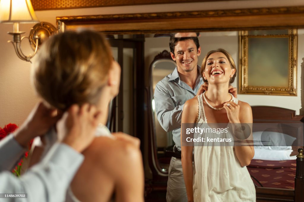 Man suprising his wife with precious pearl necklace gift