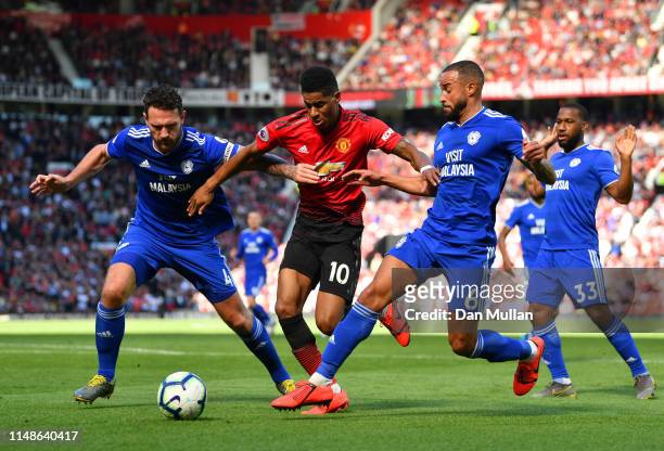 Marcus Rashford of Manchester United is tackled by Sean Morrison and Jazz Richards of Cardiff City during the Premier League match between Manchester...