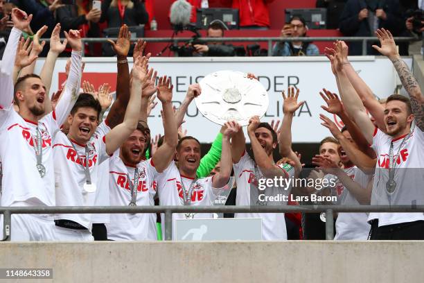 Matthias Lehmann and Jonas Hector of FC Koeln lift the Second Bundesliga trophy at the end of the Second Bundesliga match between 1. FC Koeln and SSV...