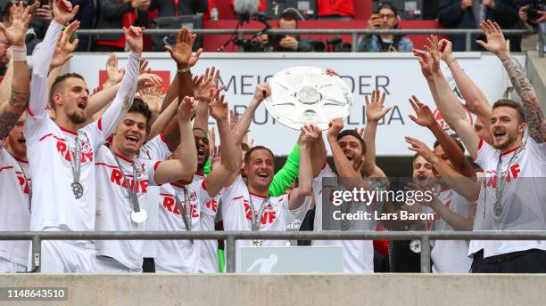 Matthias Lehmann and Jonas Hector of FC Koeln lift the Second Bundesliga trophy at the end of the Second Bundesliga match between 1. FC Koeln and SSV...