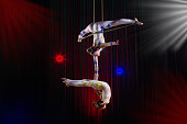 Circus actress acrobat performance. Two girls perform acrobatic elements in the air.