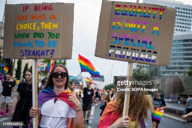 People hold rainbow flags and placards during the Warsaw Pride. The Equality March also called the Warsaw Pride parade, brought thousands of people...