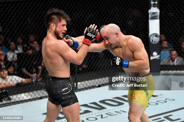 Marlon Moraes of Brazil punches Henry Cejudo in their bantamweight championship bout during the UFC 238 event at the United Center on June 8, 2019 in...