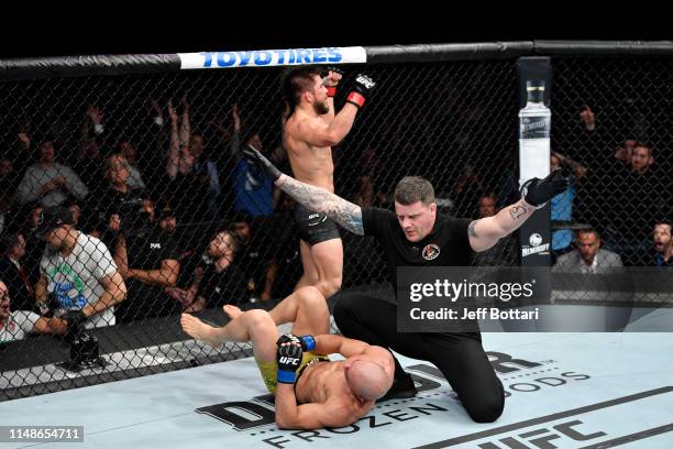 Henry Cejudo celebrates his victory over Marlon Moraes of Brazil in their bantamweight championship bout during the UFC 238 event at the United...