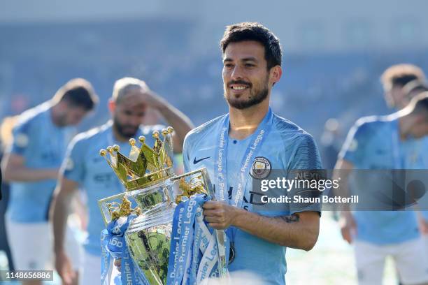 David Silva of Manchester City celebrates with the Premier League Trophy after winning the title following the Premier League match between Brighton...