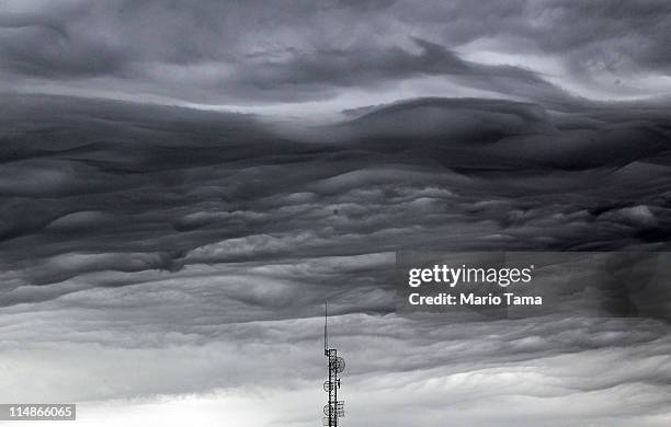 Storm cloud passes over a communications tower following a thunderstorm five days after a massive tornado after a massive tornado passed through the...