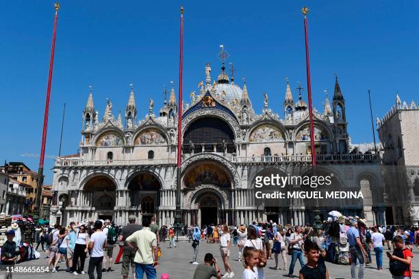 Picture taken in Venice on June 8, 2019 shows tourists taking pictures at the San Marco Basilica".
