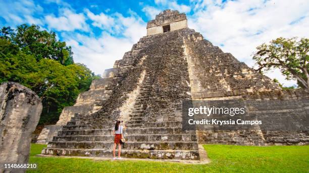 teenager using mobile phone to take pictures of tikal - guatemala - maya guatemala stock pictures, royalty-free photos & images